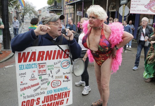 (left to right) A Christian Street preachers yells at a group hanging outside of a bar whiledrag queen Charles Loraine Wendell yells back on Bourbon Street in the French Quarter during Fat Tuesday Mardi Gras celebrations in New Orleans, Louisiana USA on Tuesday 12 February, 2013. Fat Tuesday is the final day of Mardi Gras celebrations in New Orleans.